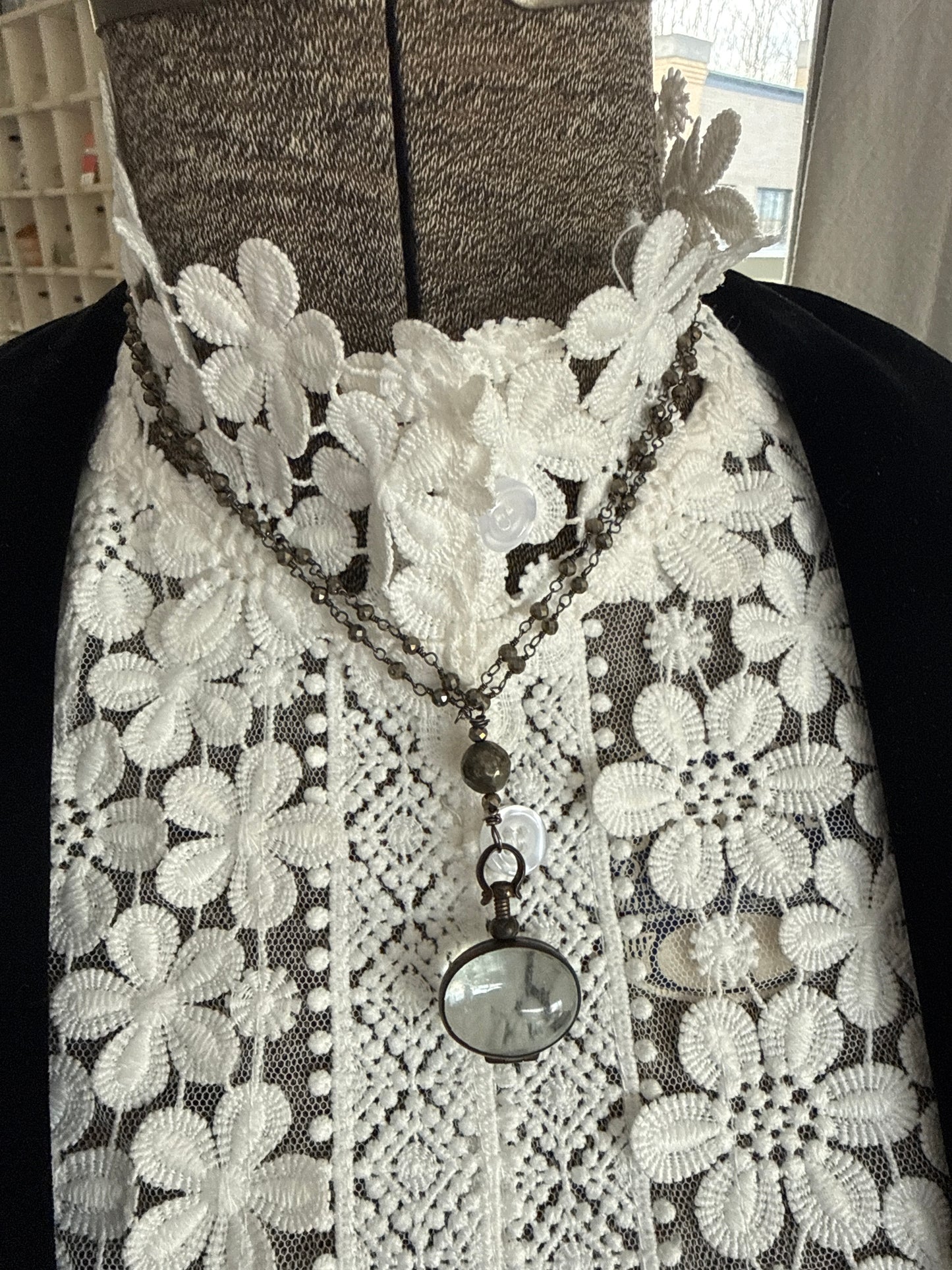 Antiqued bronze glass locket on pyrite chain. 32”