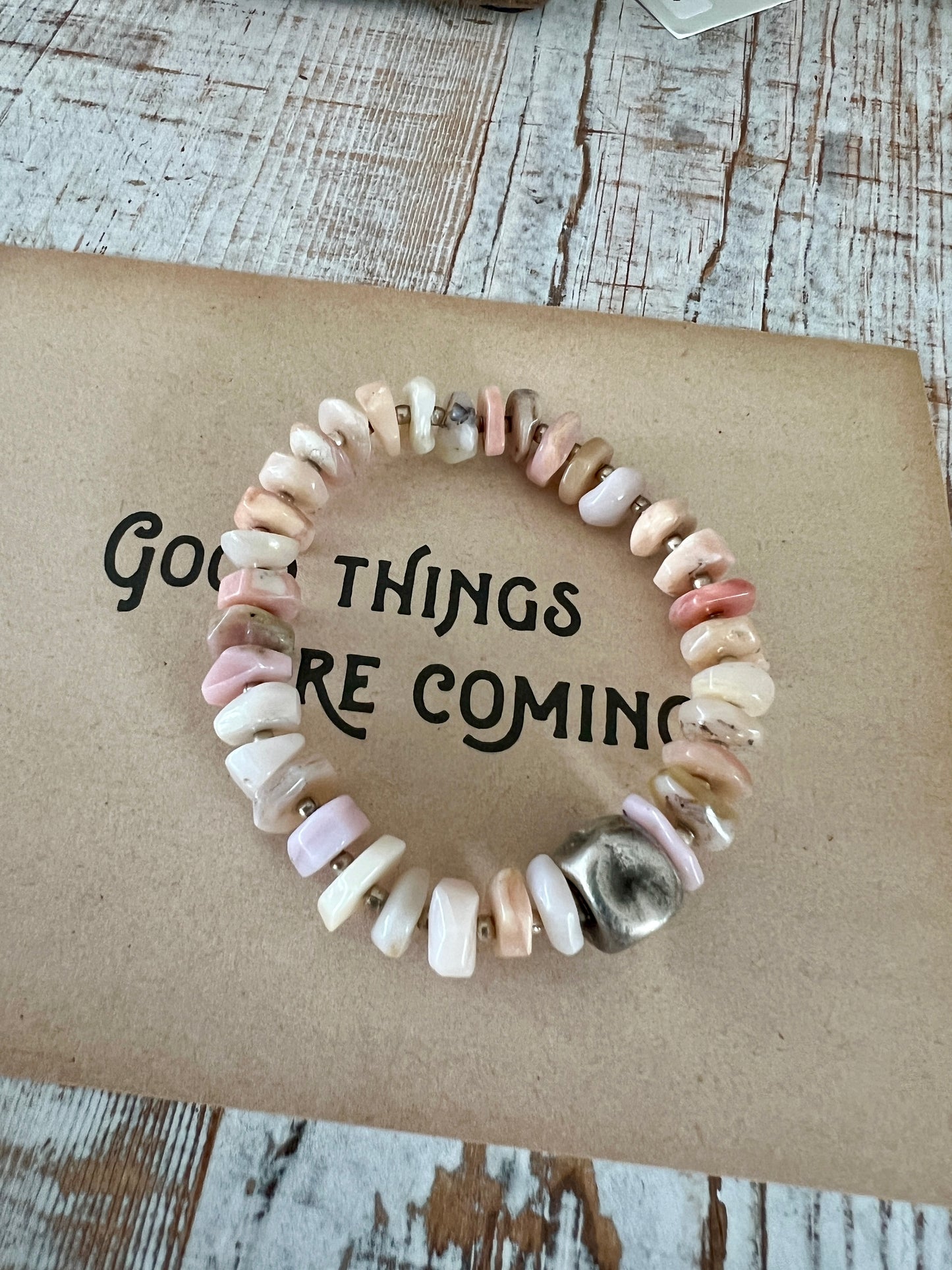 Heishi cut pink opals surround a fine silver pinched cube. Fine silver spacers. 6” stretch stack bracelet.