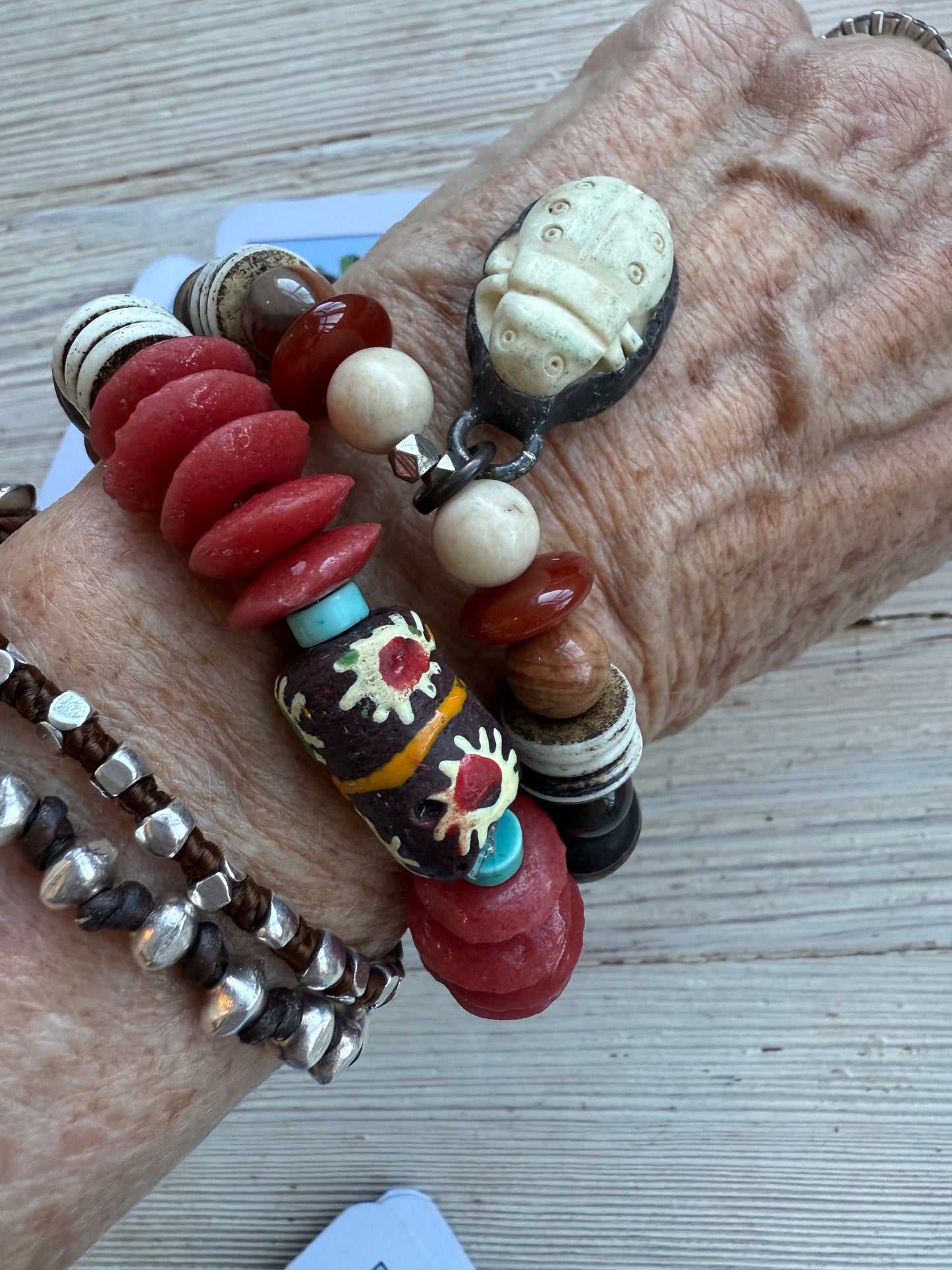 A bone scarab dangles from a mix of earthy beads stretch bracelet 6.5-7”