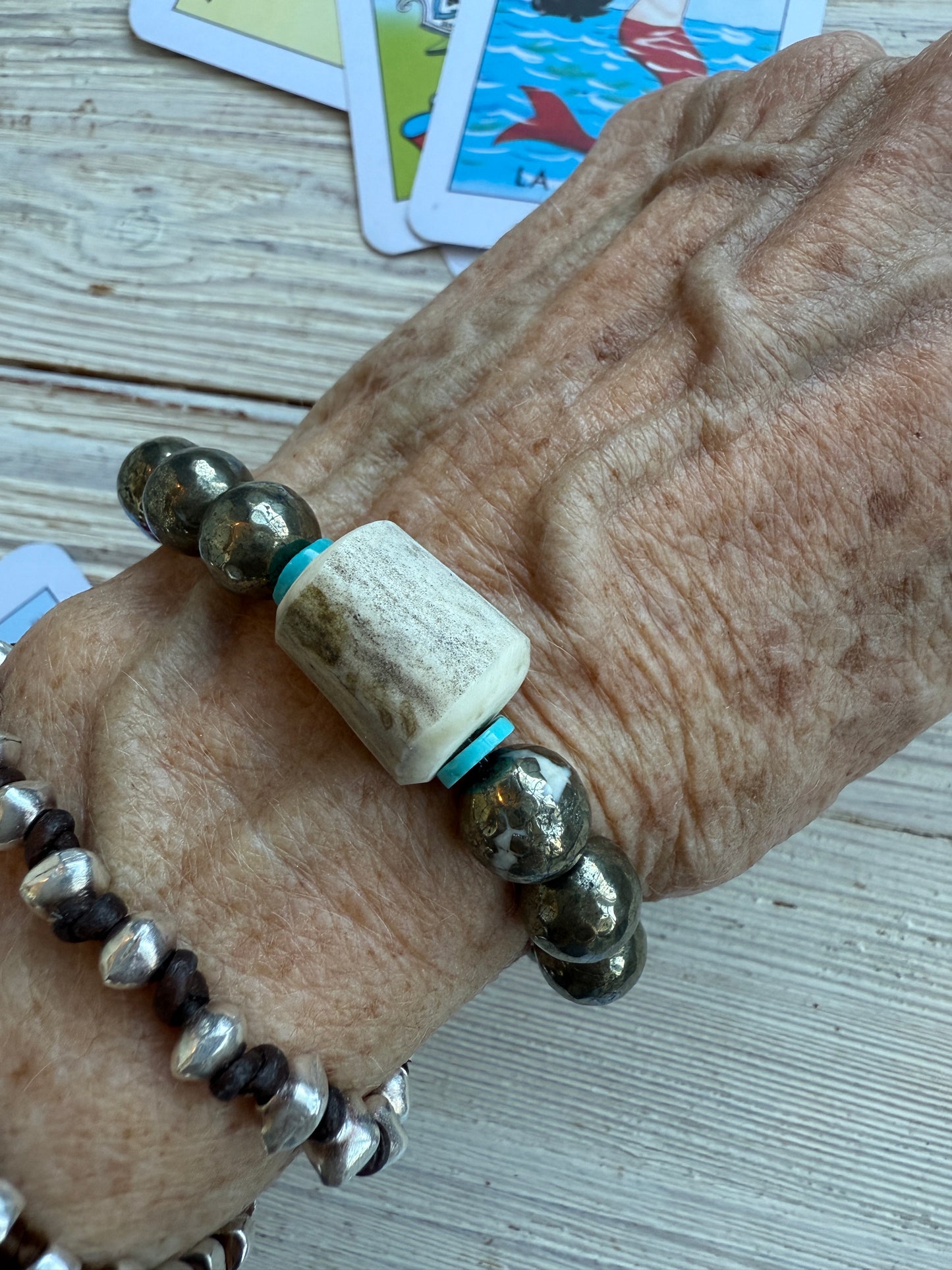 Pyrite beads surround an antler with turquoise accents stretch bracelet. 6.5”