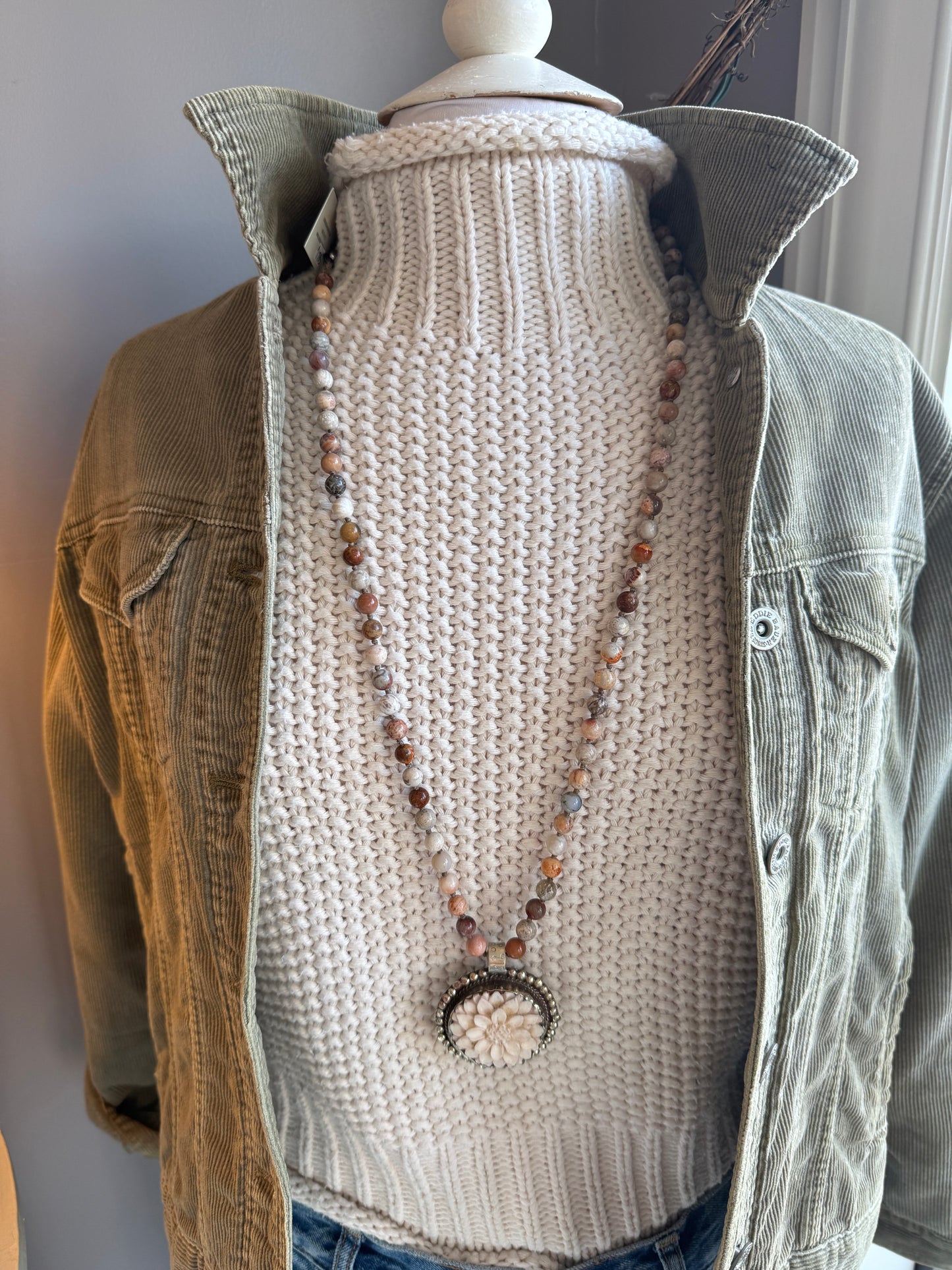 Tibetan carved bone dahlia on knotted fossilized coral long necklace.