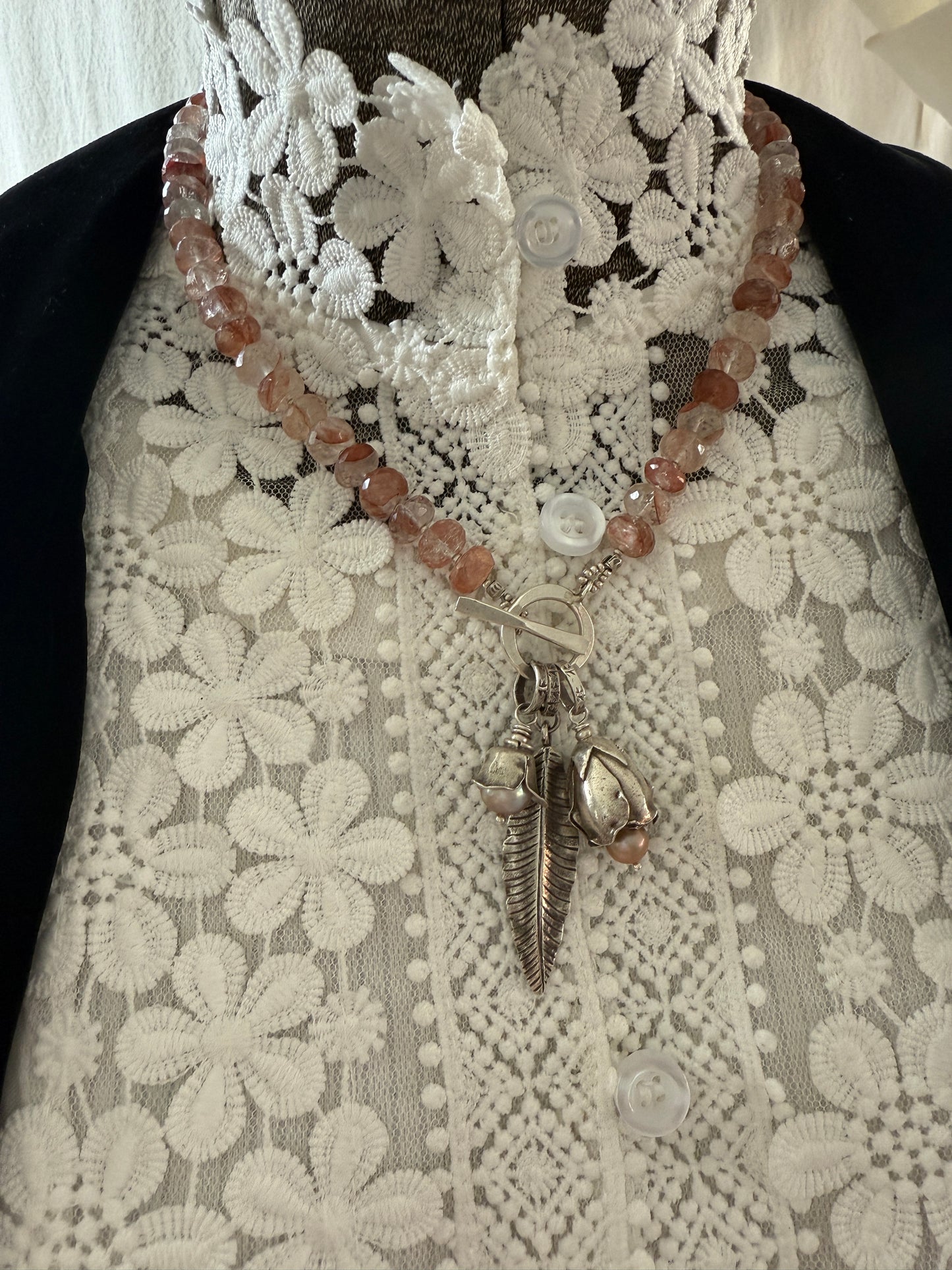 Hematoid quartz with fine silver spacers with fine silver rosebud, rose, and leaf on a fine silver front toggle necklace. 18”