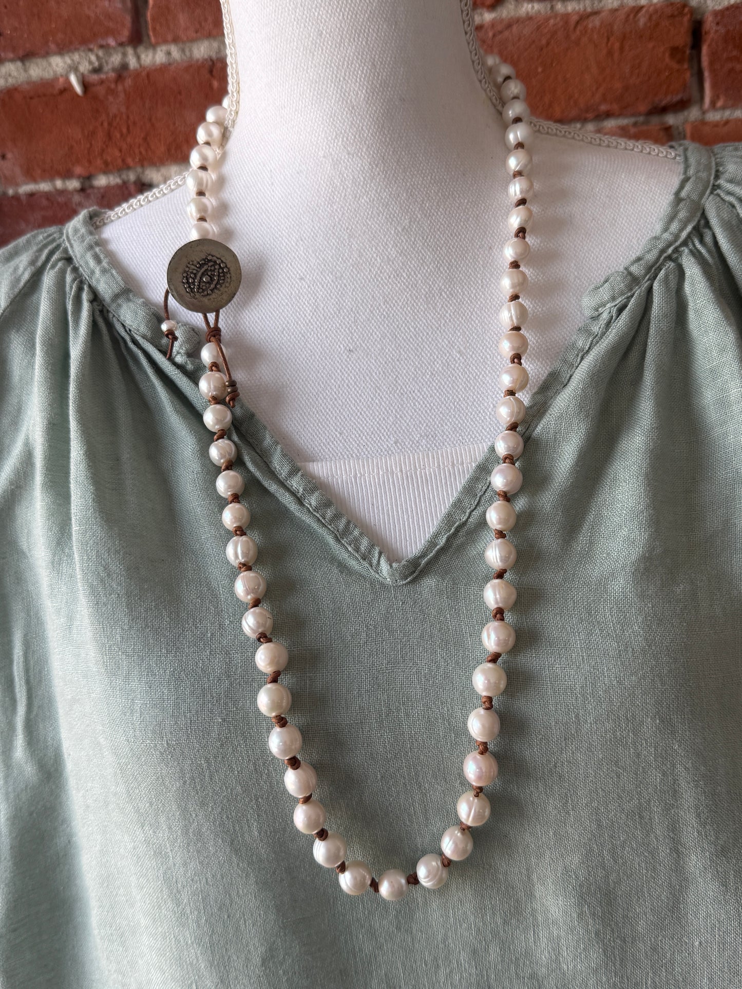 White pearls knotted on leather long necklace with removable tassel.