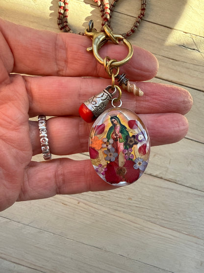 Our Lady. Dried flowers under resin. Handmade with sterling bezel on knotted striped Java beads. 35” necklace.