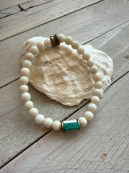 White riverstone stretch stack bracelet with turquoise and bone inlay bead from Nepal. 6.5”