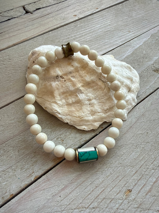 White riverstone stretch stack bracelet with turquoise and bone inlay bead from Nepal. 6.5”