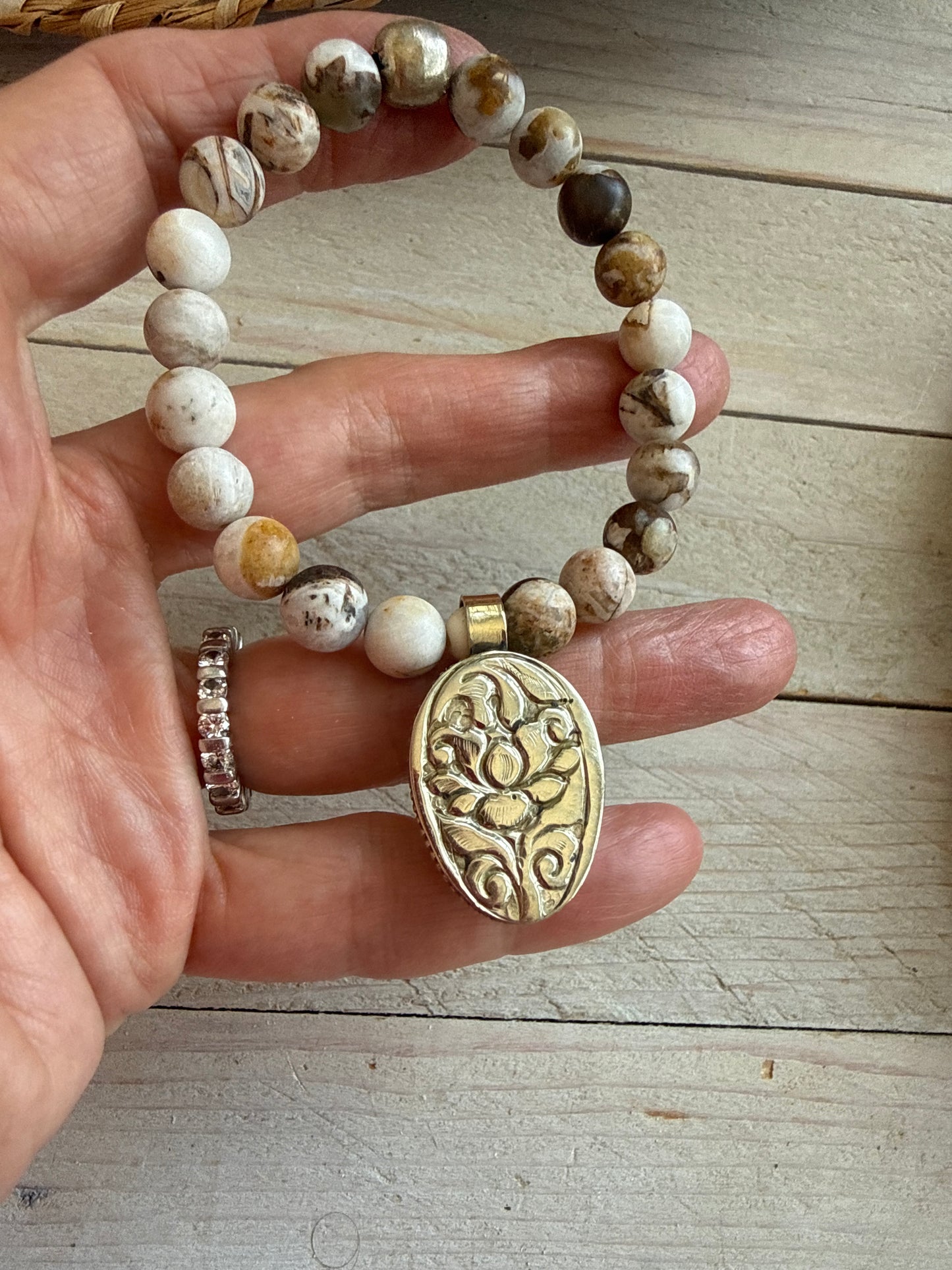 Wood opal and Tibetan cowrie shell charm with repousé back stretch stack bracelet. 6.5-7”