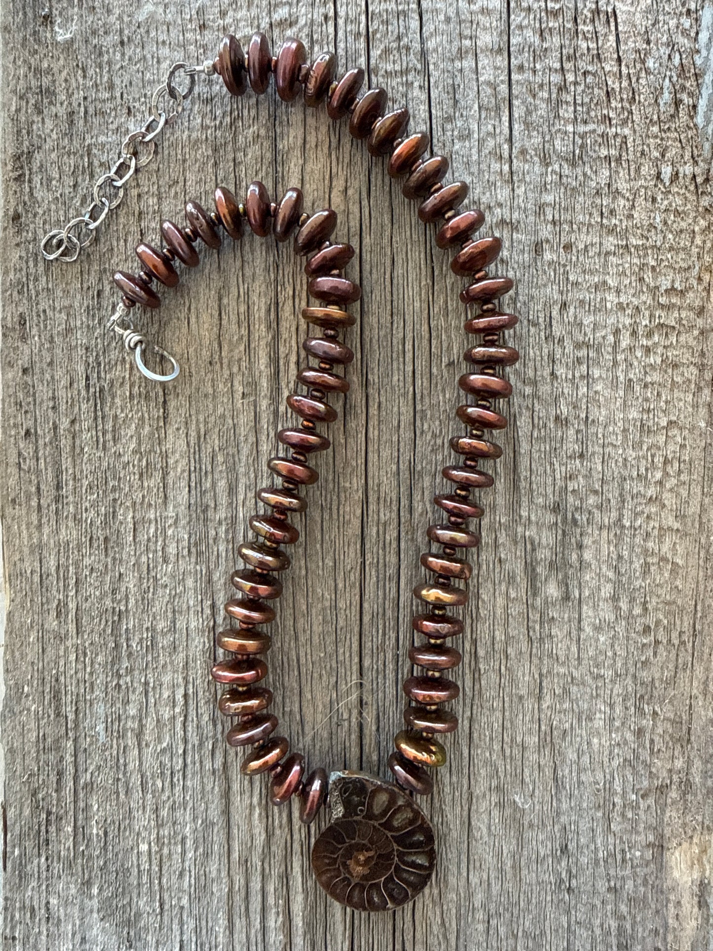 A natural ammonite fossil and chocolate brown button pearl necklace.