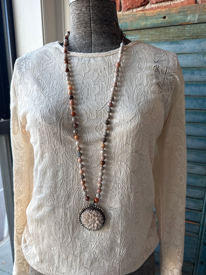 Tibetan carved bone dahlia on knotted fossilized coral long necklace.