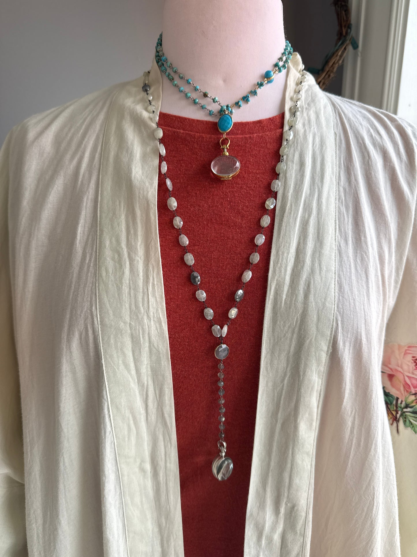 Turquoise rosary style chain with turquoise and gold accent pieces and brass locket necklace.