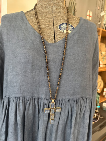 Blue kyanite cross on knotted smoky quartz necklace with fine silver flower accents.