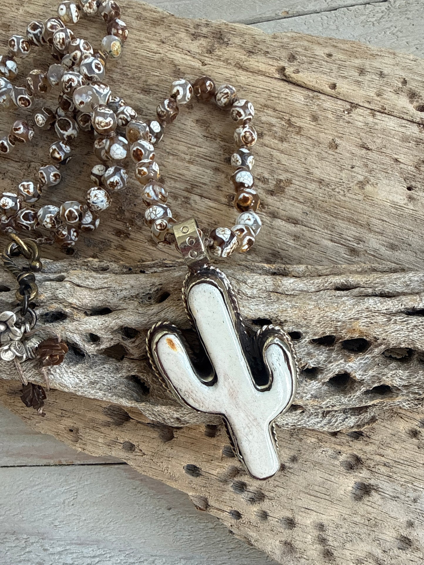 Bone cactus pendant on Dzi agates with fine silver embellishments. 34.5”