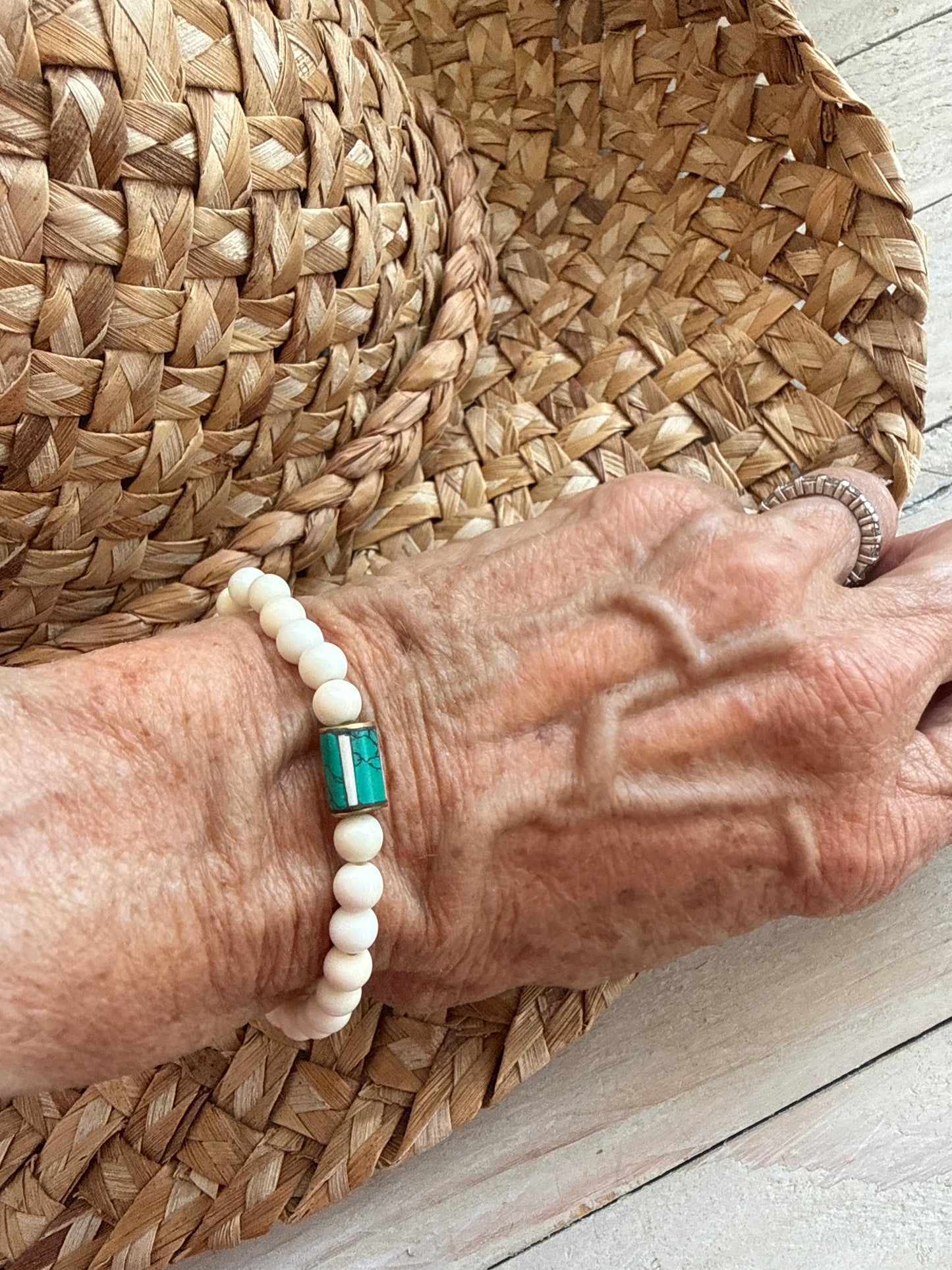 White riverstone stretch stack bracelet with turquoise and bone inlay bead from Nepal. 6.5”