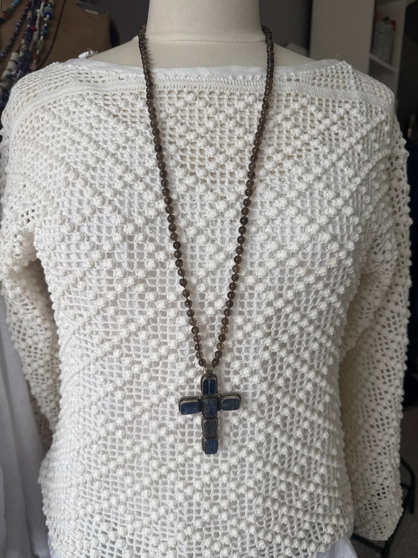 Blue kyanite cross on knotted smoky quartz necklace with fine silver flower accents.