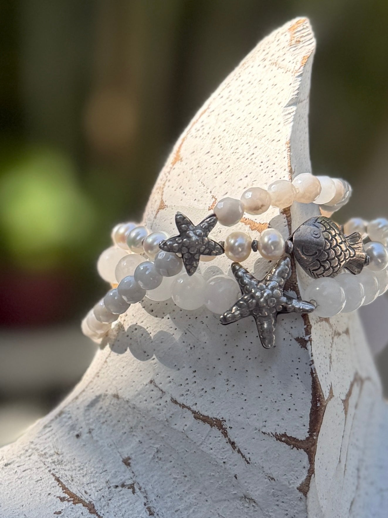 A small, fine silver starfish adorns this faceted moonstone bracelet. 7-7.5” stretch.