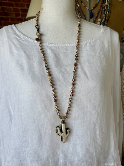 Bone cactus pendant on Dzi agates with fine silver embellishments. 34.5”