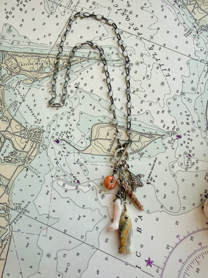 Oxidized sterling chain necklace with front toggle, bumblebee jasper fish, fine silver starfish, white coral, shell, and spiny oyster danglies.