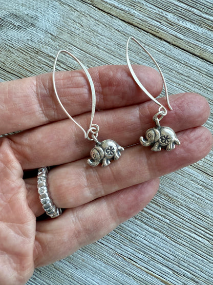 Fine silver elephant earrings on elliptical sterling ear wires.