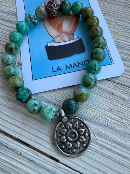 Turquoise beads with a vintage sterling bead and charm stretch bracelet. 6.5-7”