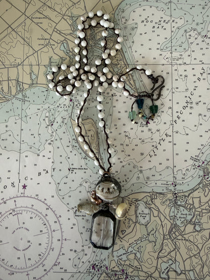 Long braided white magnesite with soldered shell and crystal pendant with pearls, trade bead, shell, and fish charm.
