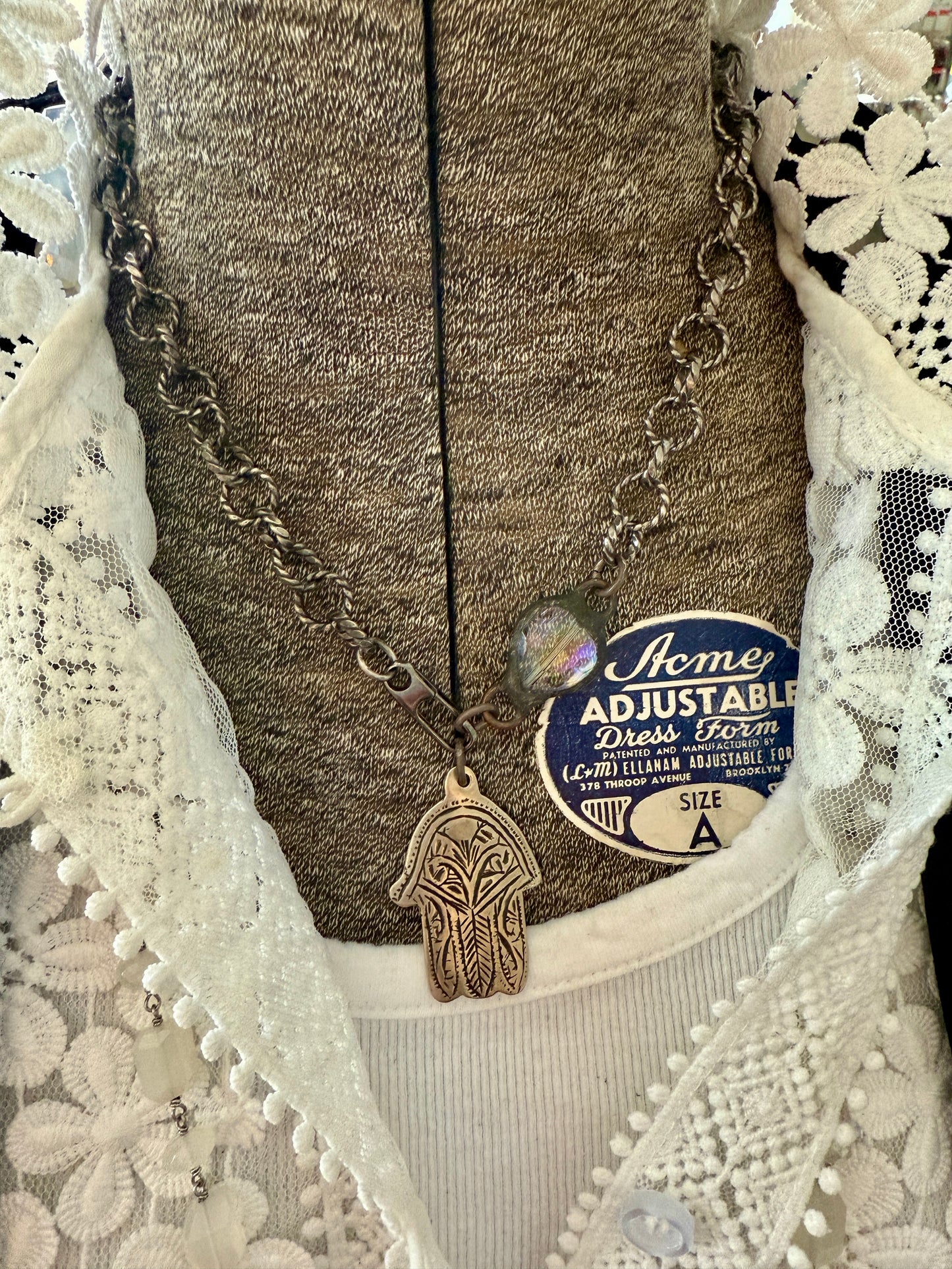 Chunky oxidized sterling rope chain with a crystal hear, sterling carabiner clasp, and stamped bronze hamsa pendant. 18”