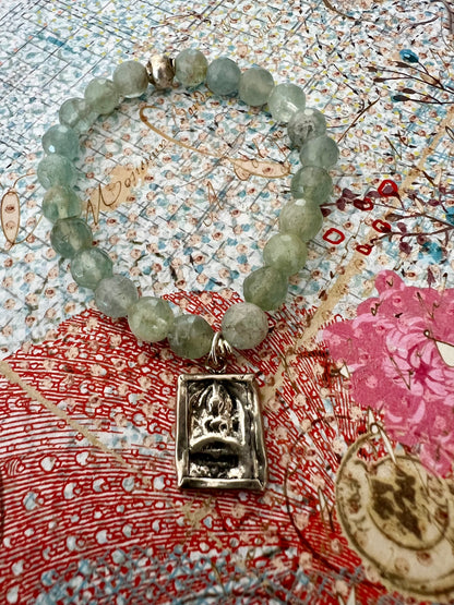 Bracelet of faceted aquamarines with a solid sterling silver sitting Buddha charm.