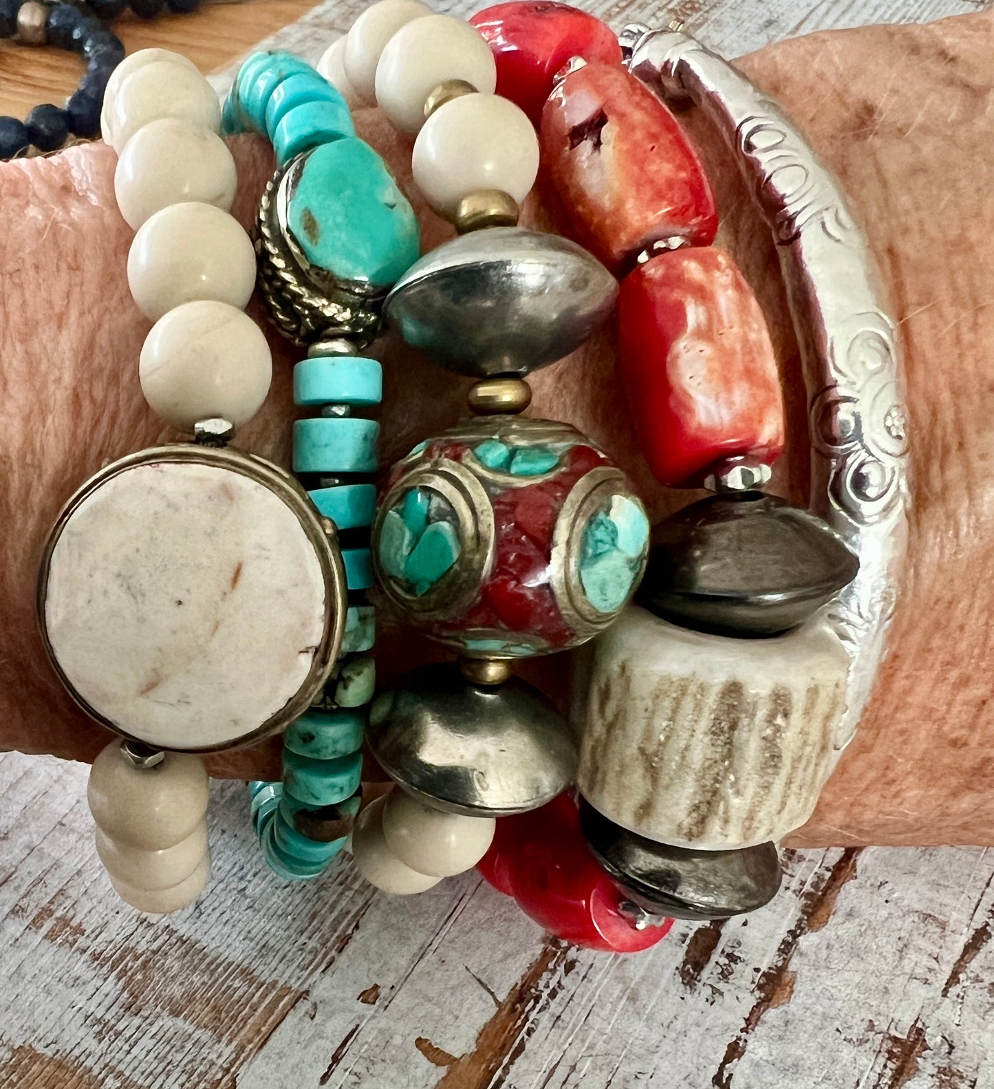 Tibetan inlay bead with coral and turquoise on matte riverstone beads. Stack stretch bracelet.