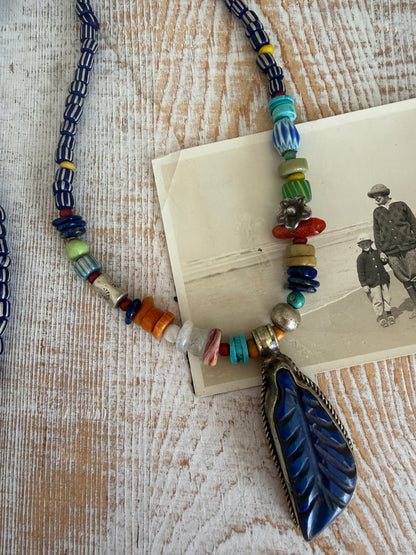 Carved lapis lazuli leaf from Tibet on a mix of gems and trade beads necklace. 25”.