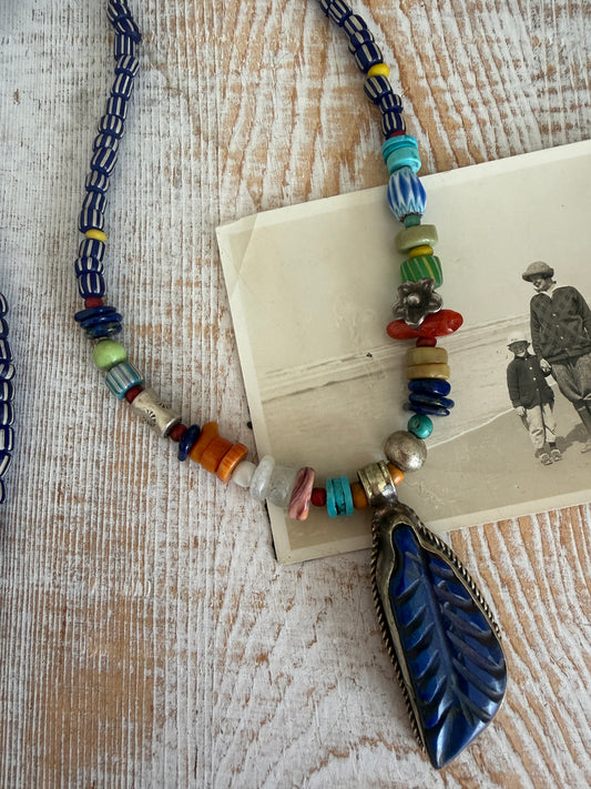 Carved lapis lazuli leaf from Tibet on a mix of gems and trade beads necklace. 25”.