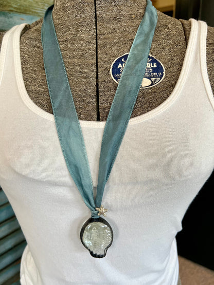 Glass fish on blue silk ribbon with fine silver accents.