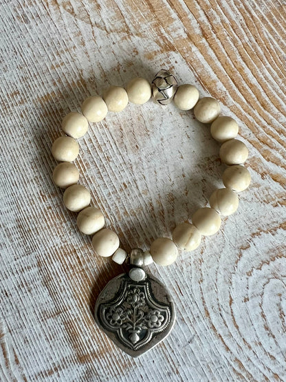 Old Tibetan sterling silver talisman on riverstone beads. Stack bracelet. 6-6.5”