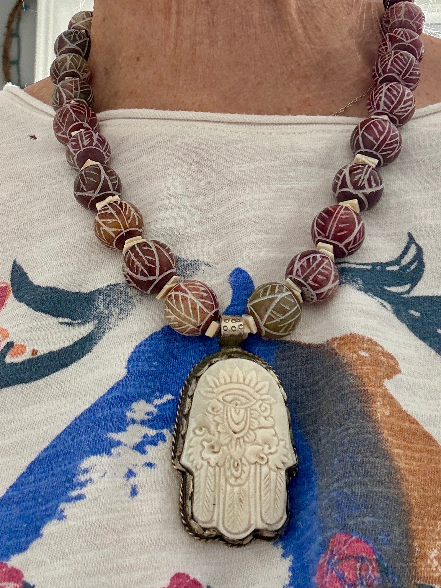 Carved red jade with carved bone hamsa short necklace.