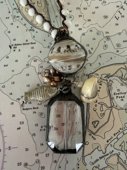 Long braided white magnesite with soldered shell and crystal pendant with pearls, trade bead, shell, and fish charm.