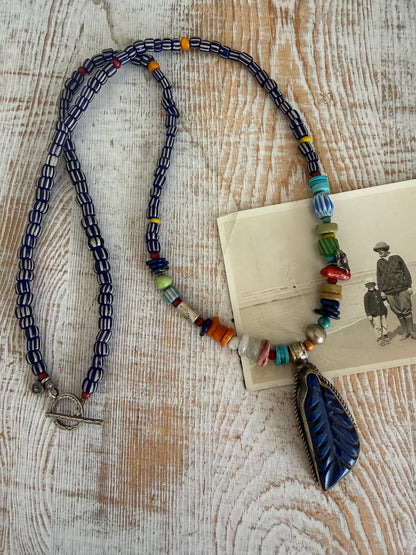 Carved lapis lazuli leaf from Tibet on a mix of gems and trade beads necklace. 25”.