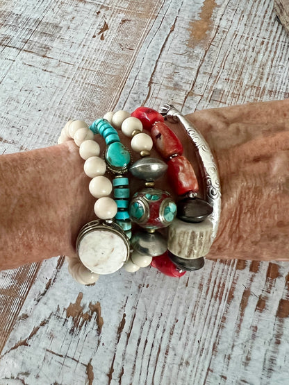 Tibetan inlay bead with coral and turquoise on matte riverstone beads. Stack stretch bracelet.