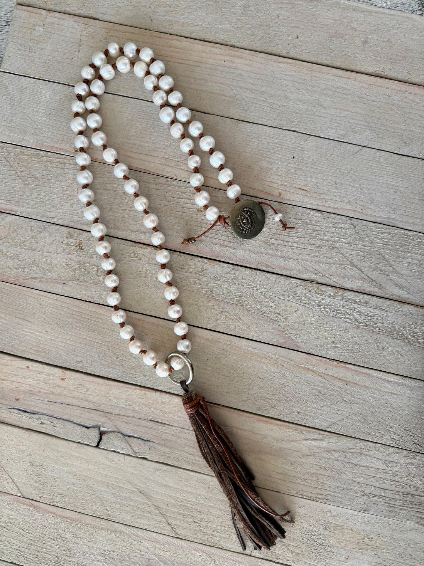 White pearls knotted on leather long necklace with removable tassel.