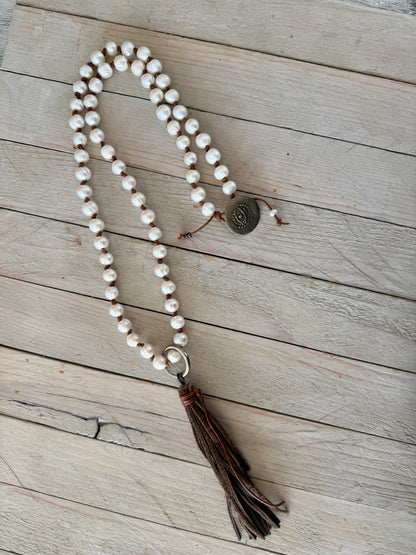White pearls knotted on leather long necklace with removable tassel.
