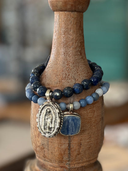 Tibetan blue kyanite pendant suspended from matte blue aventurine stack stretch bracelet. 7”