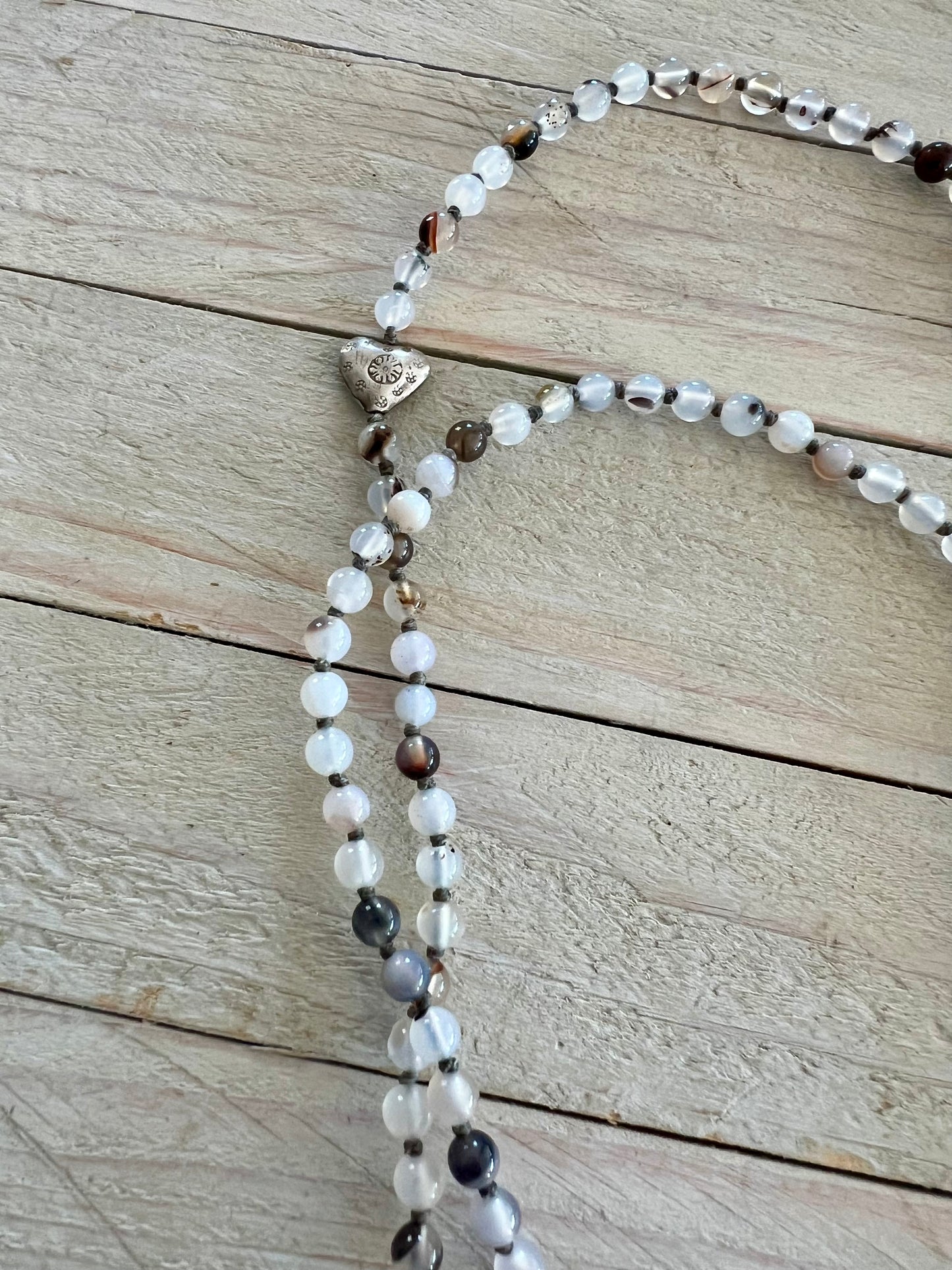 Pearl cross on knotted agates with fine silver heart accent. 44” necklace.