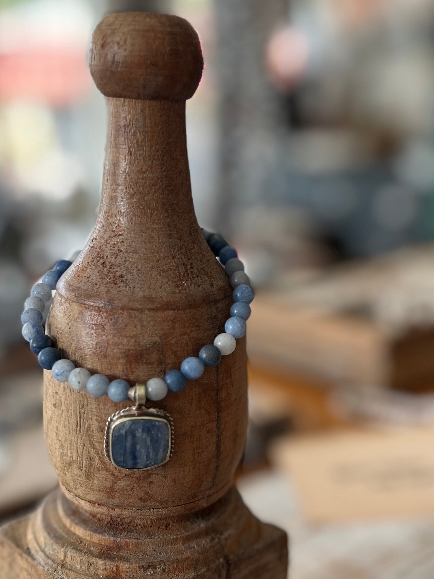 Tibetan blue kyanite pendant suspended from matte blue aventurine stack stretch bracelet. 7”