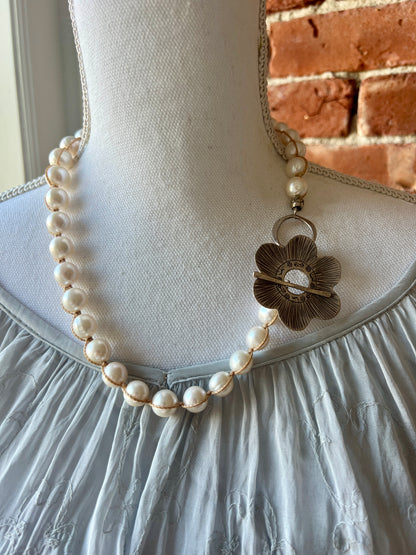 Fine silver flower on hand knotted pearls necklace. Front or side toggle