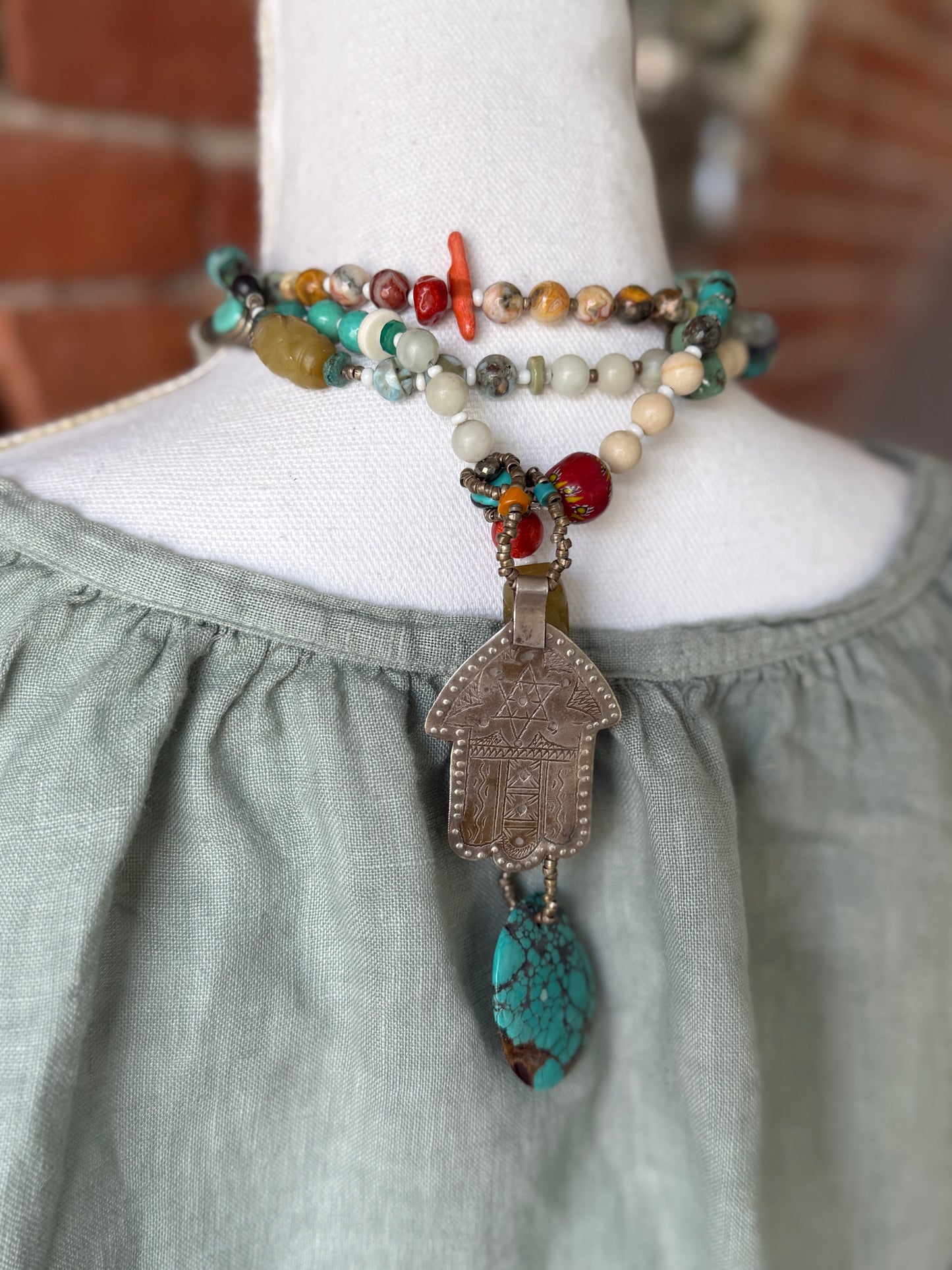 57” of turquoise Amazonite, Jasper, larimar, jade, riverstone, trade beads, Ethiopian silver, broom coral, and others lariat necklace with sterling hamsa and turquoise necklace.