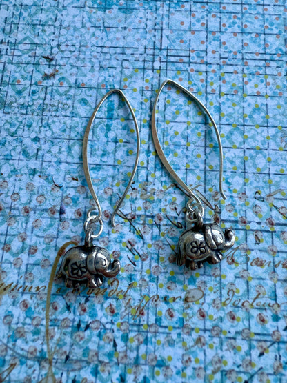 Fine silver elephant earrings on elliptical sterling ear wires.