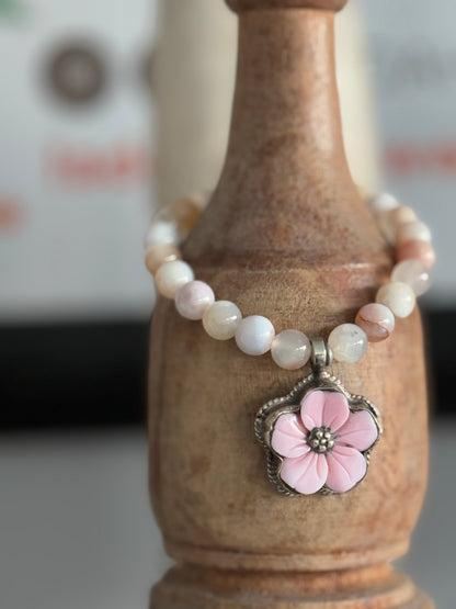 Tibetan carved Peruvian Opal charm on cherry blossom agate beads stretch bracelet. 6.5”