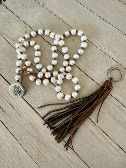 White pearls knotted on leather long necklace with removable tassel.