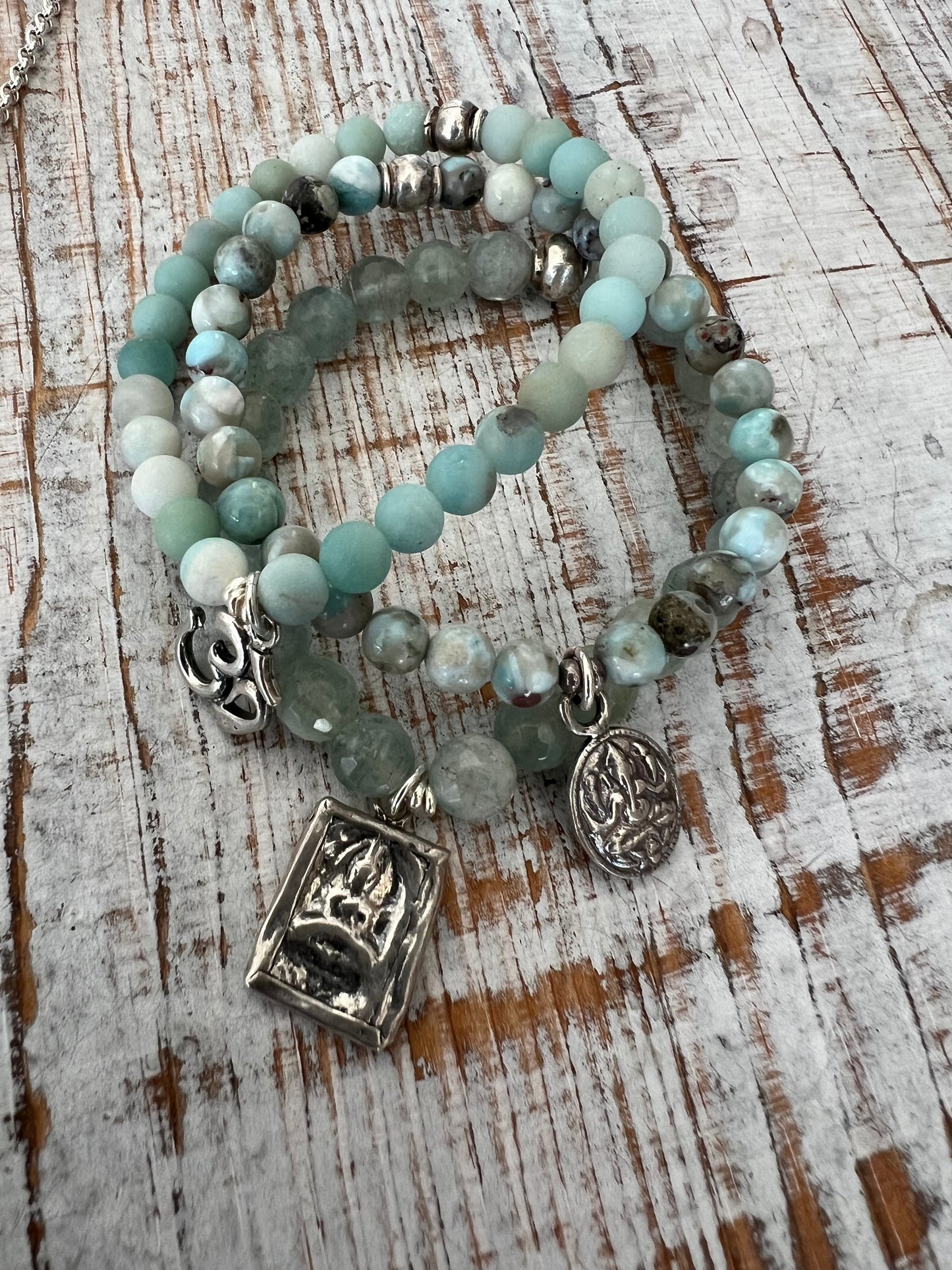 Bracelet of faceted aquamarines with a solid sterling silver sitting Buddha charm.