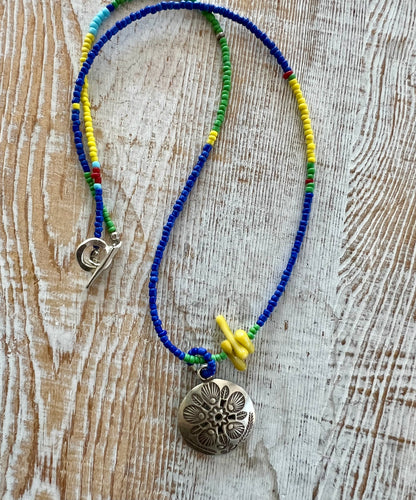 Stamped Thai pendant with colorful Java glass seed beads necklace.