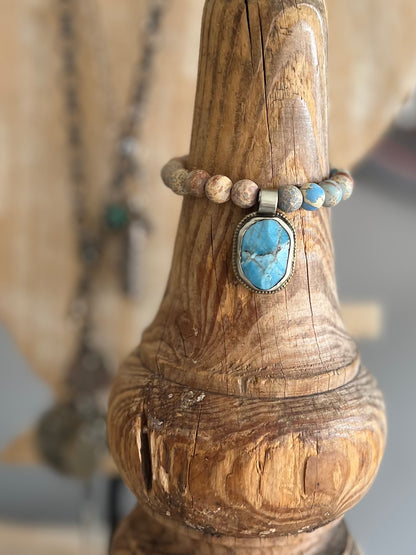 Tibetan turquoise pendant surrounded by sea sediment Jasper. Stretch bracelet 6.5” (small wrist).