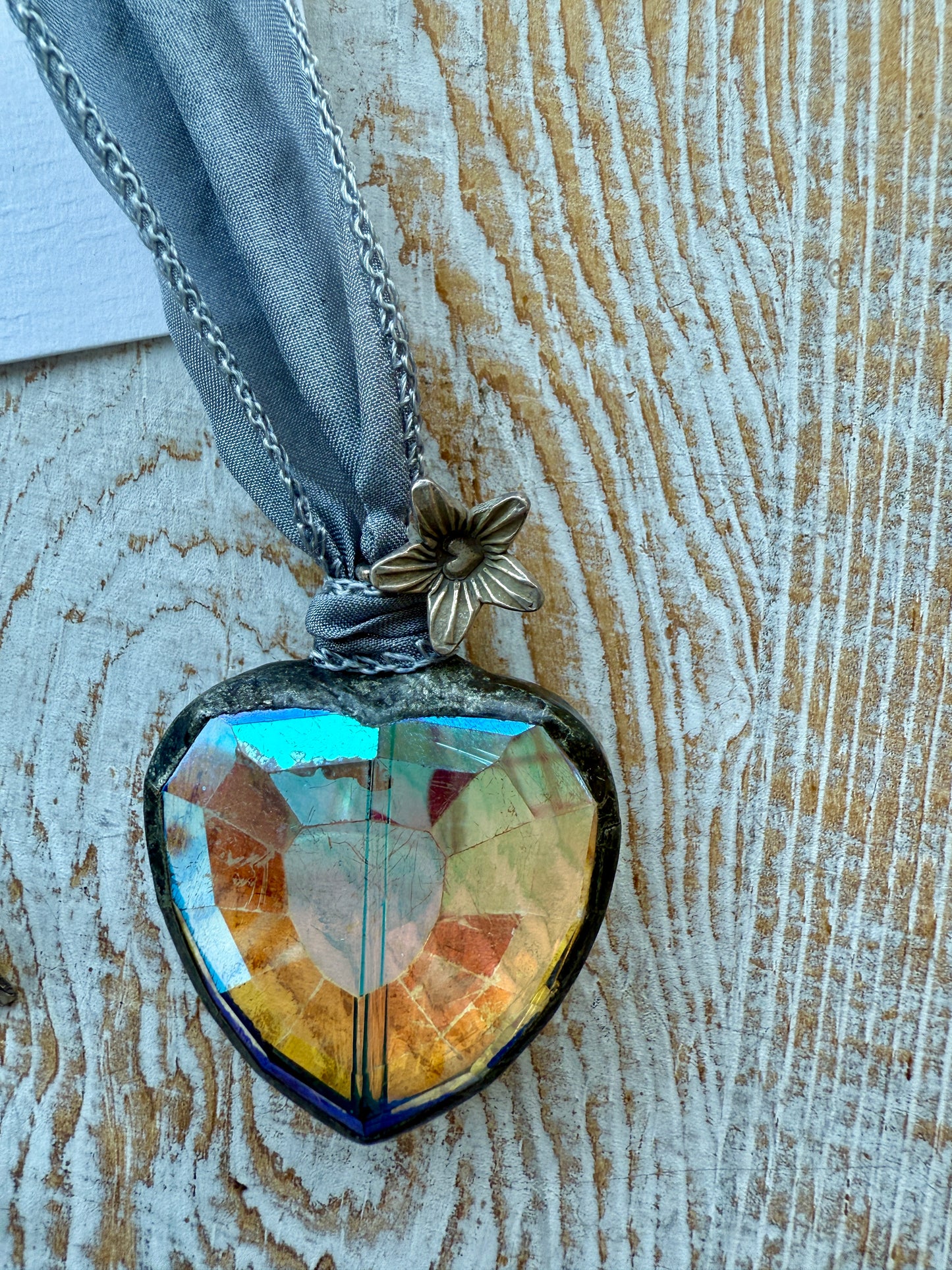 Prism heart on pale blue silk ribbon with fine silver flower charms. 36”.