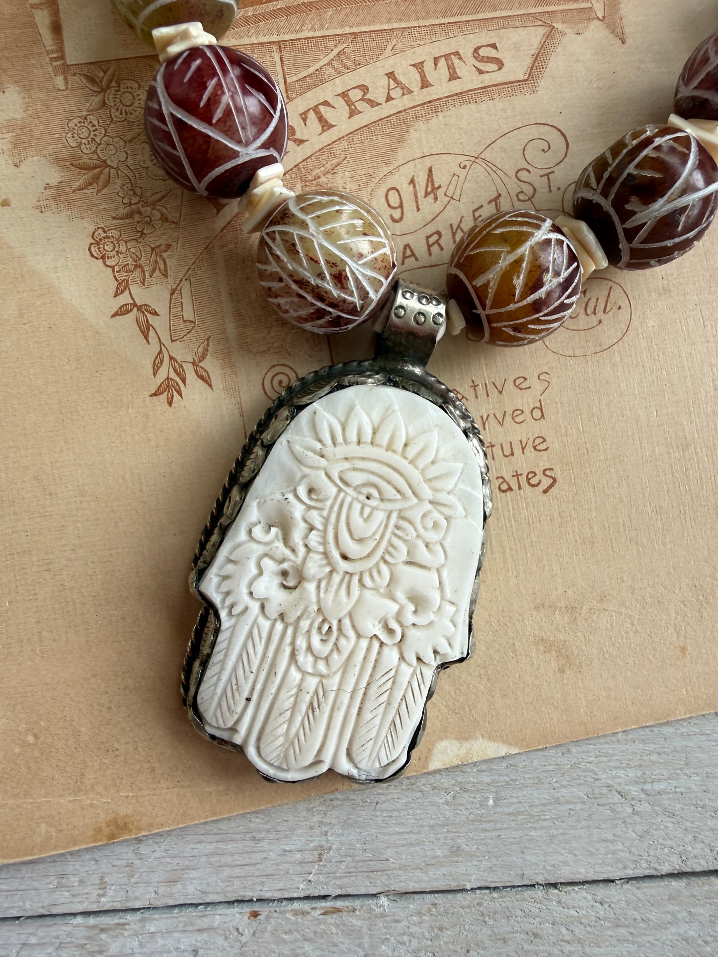 Carved red jade with carved bone hamsa short necklace.